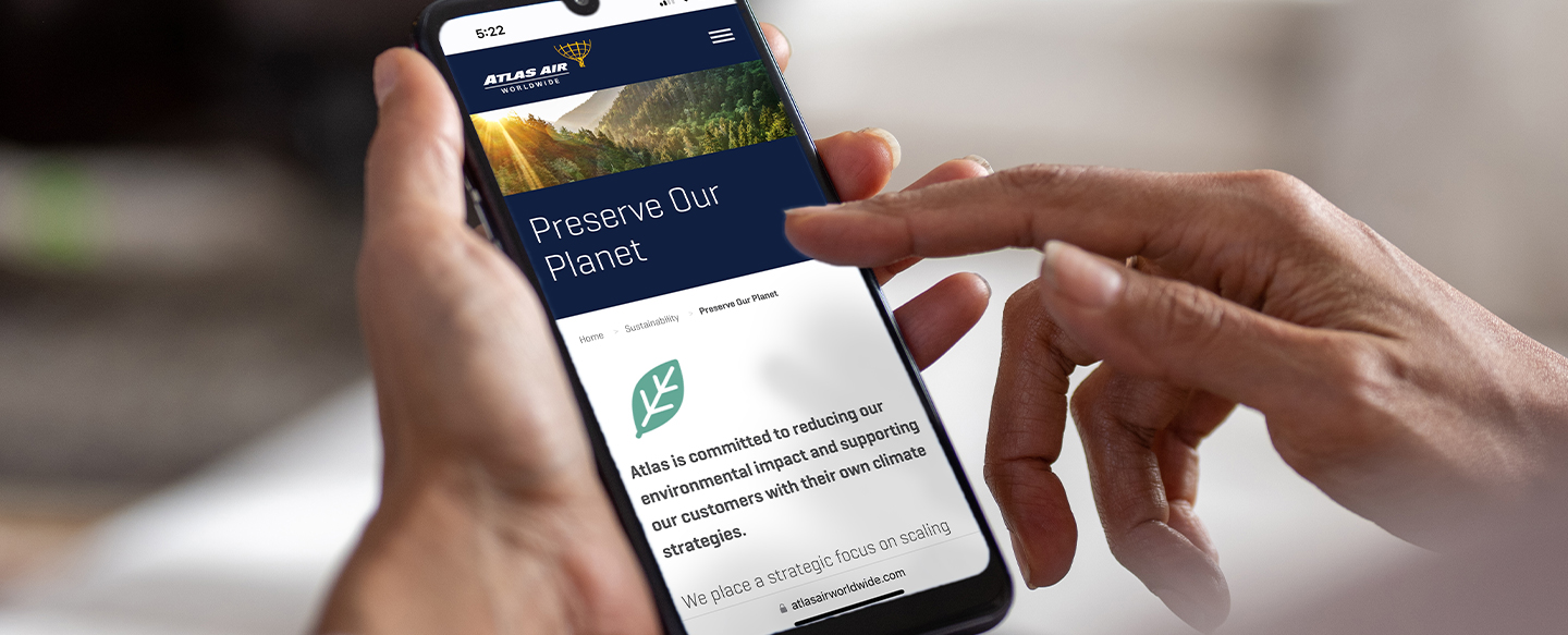Mobile phone with Atlas Air Worldwide's sustainability page loaded